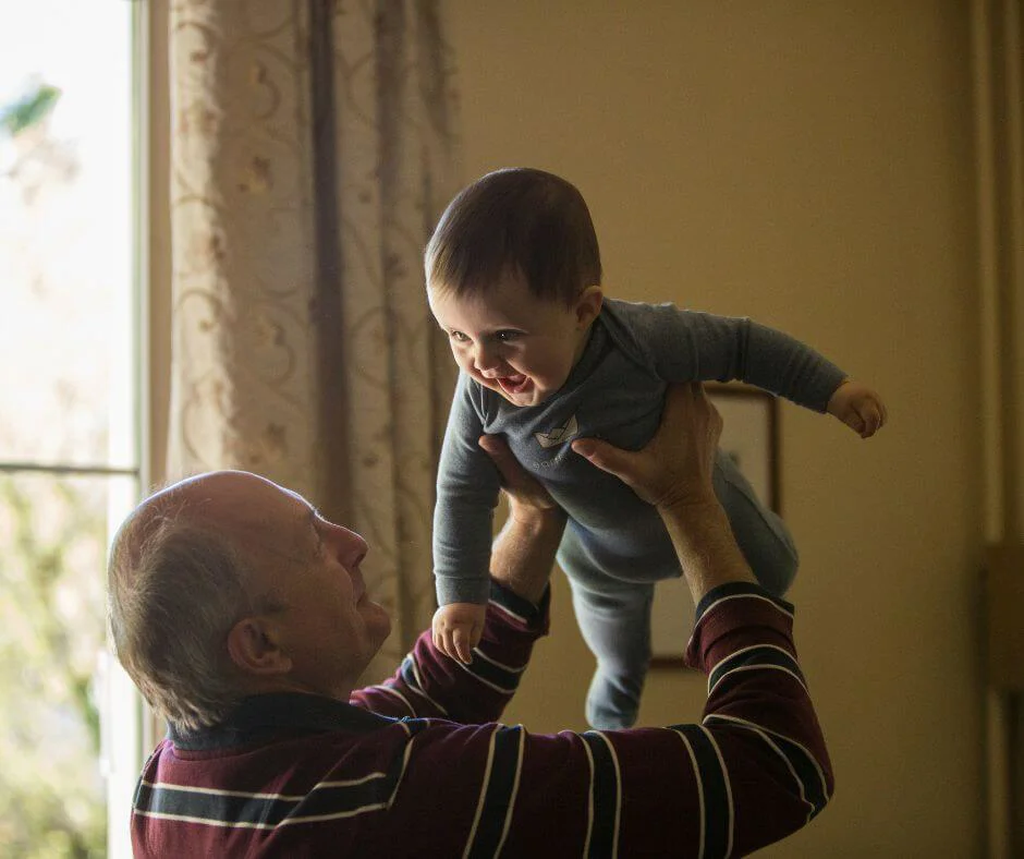 Older man holding baby boy in the air Older man holding baby boy in the air