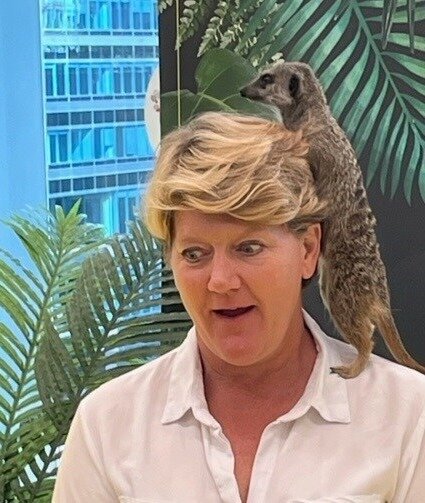 Clare Balding looking surprised with meerkat on shoulder