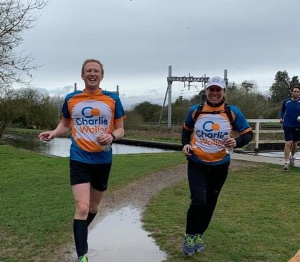 Man and woman running in Charlie Waller branded tops