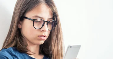 Young girl looking at a smart phone Young girl looking at a smart phone