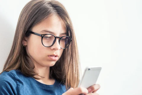 Young girl looking at a smart phone Young girl looking at a smart phone