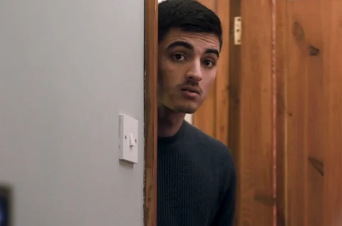 Raman, a young man peeking around a door frame Raman, a young man peeking around a door frame