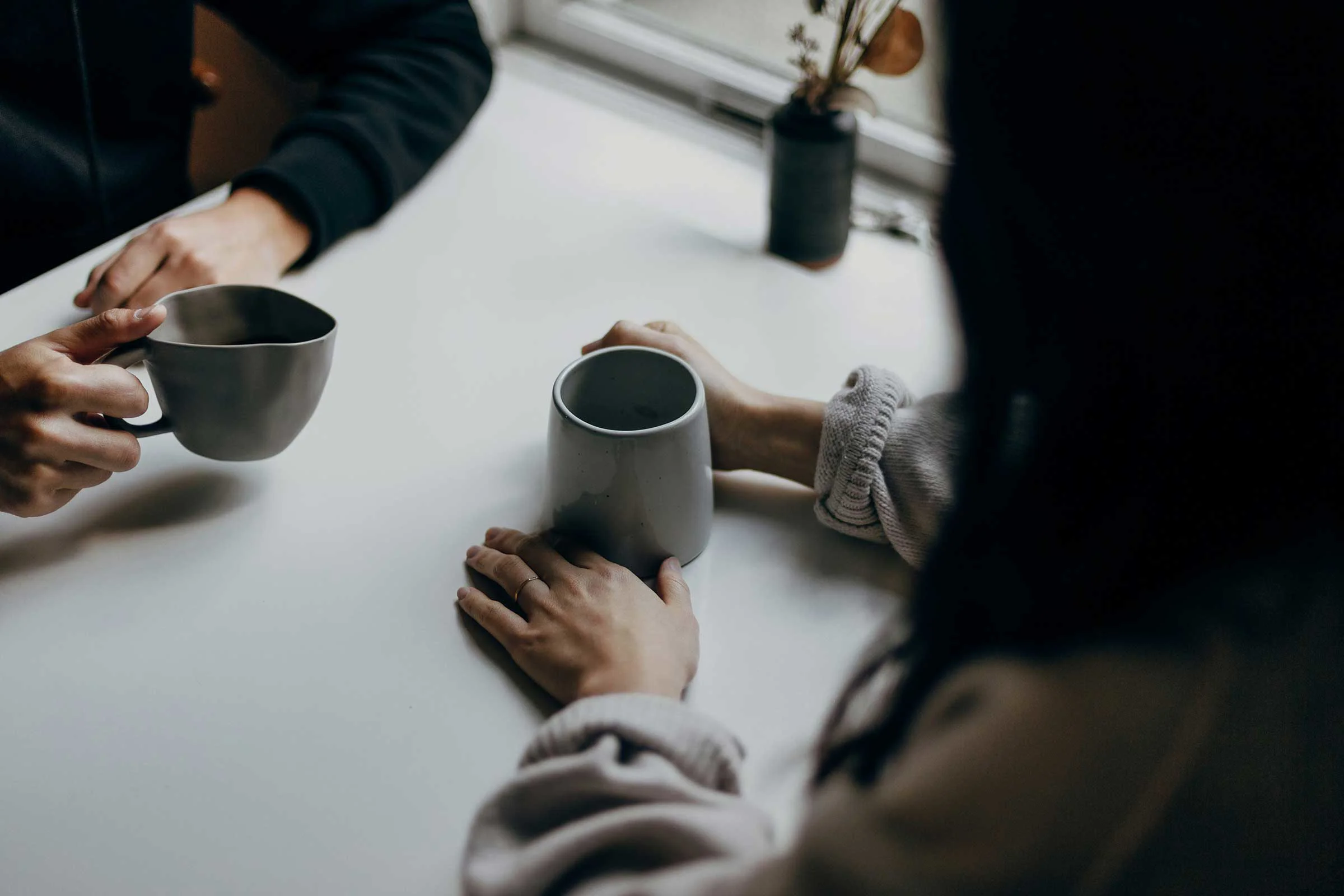 Two people's hands holding cups Two people's hands holding cups