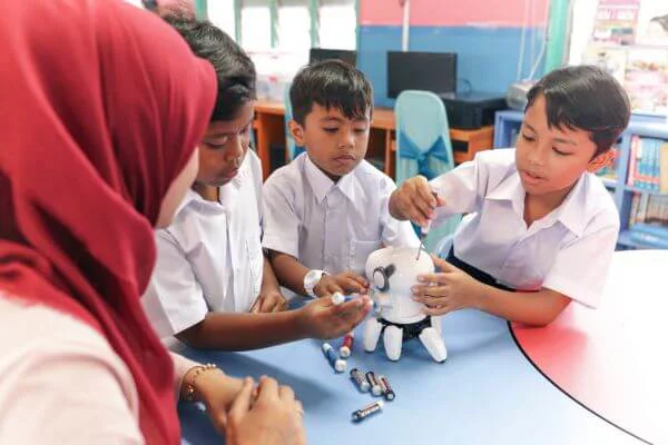 A teacher who is wearing a hijab playing with students A teacher who is wearing a hijab playing with students