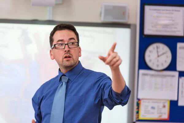 Teacher pointing at the front of a class