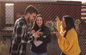 Three young people looking at phone