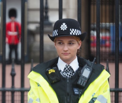 Police woman in front of a gate