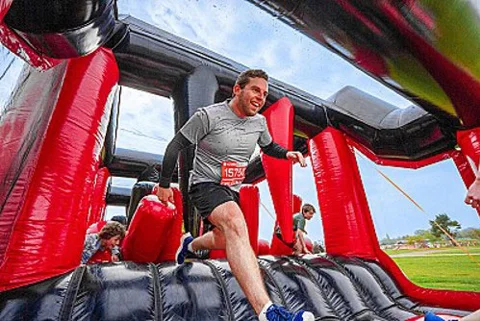 A man running across the inflatable course A man running across the inflatable course