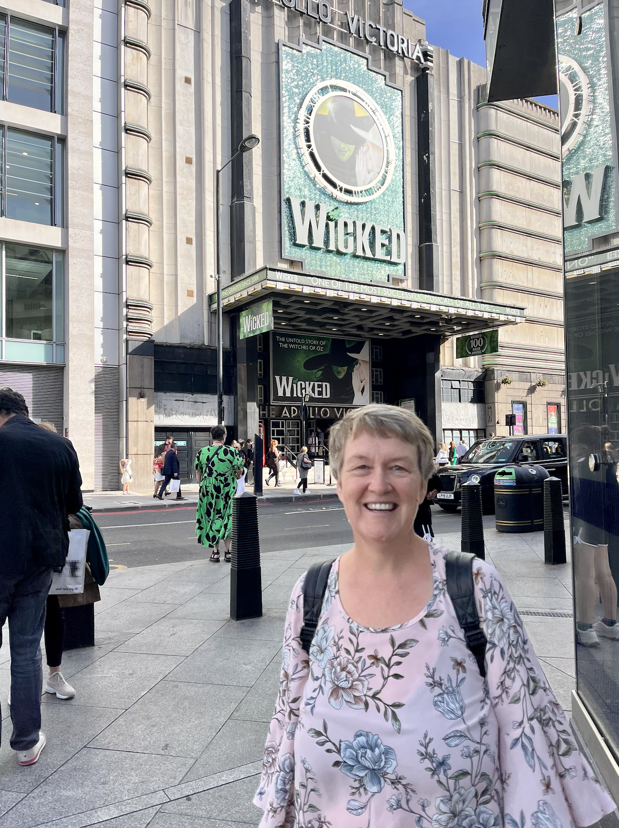 Sarah Wyatt, a white woman with short hair standing in front of a theatre.