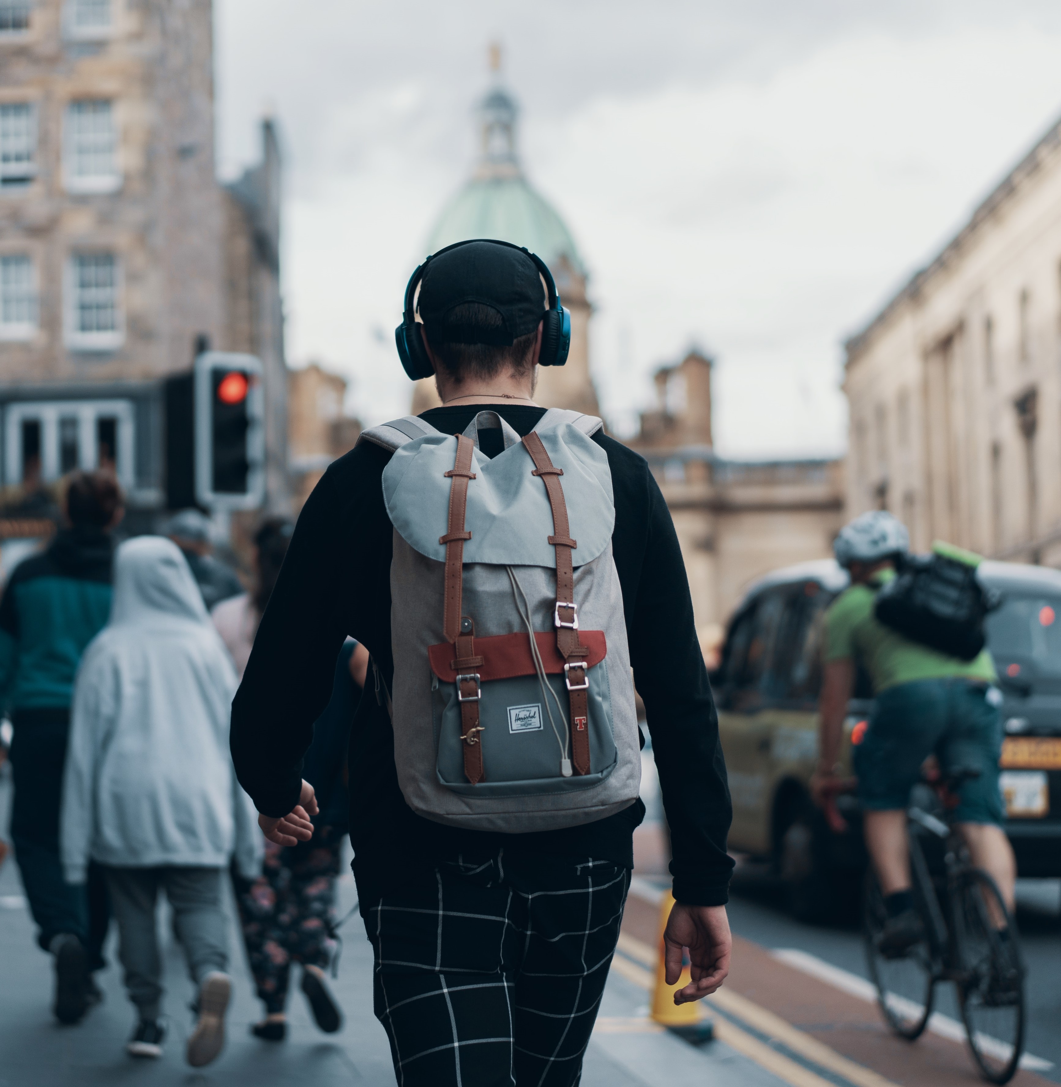 Image of man walking with headphones on in the city