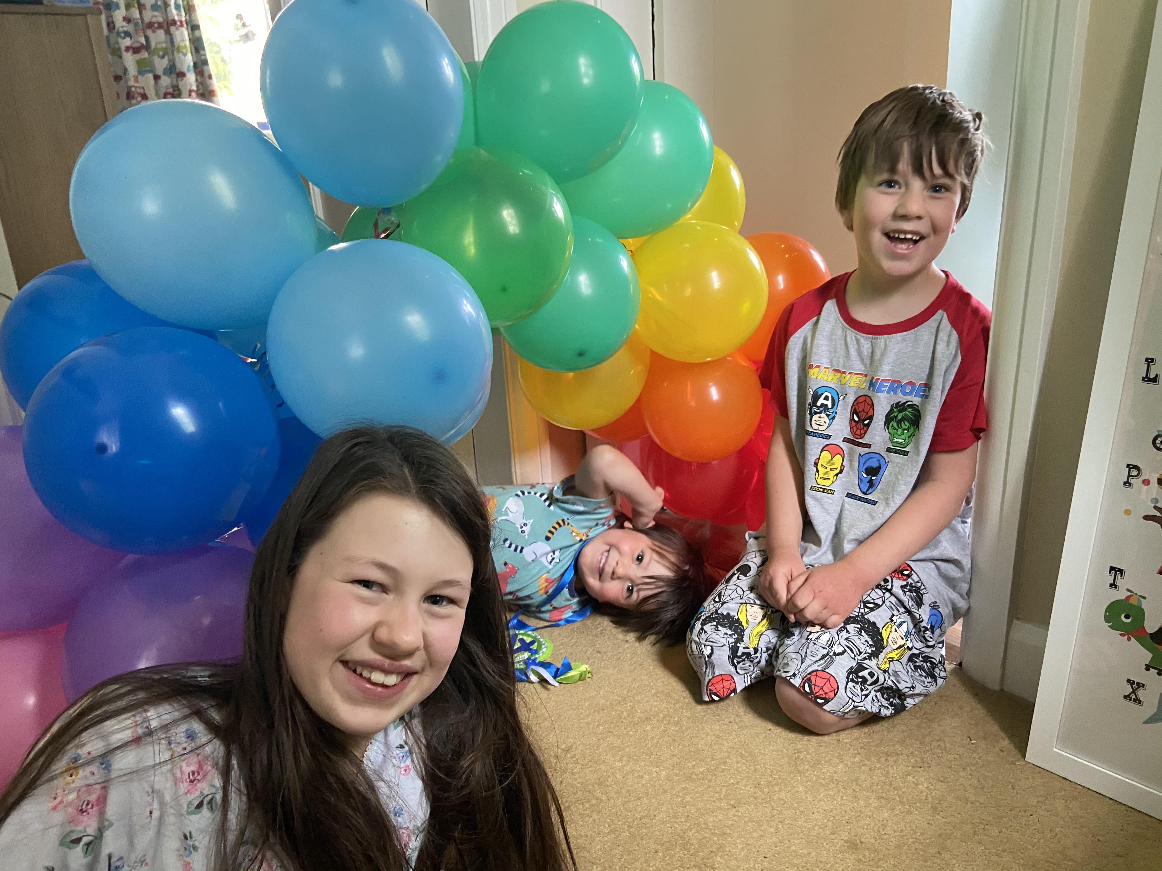 smiling children at home with rainbow balloons