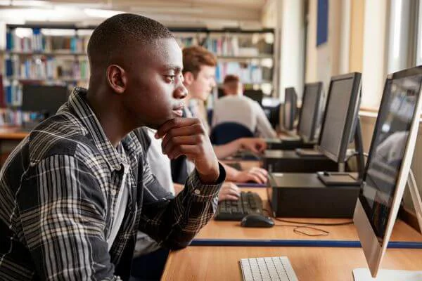 Black student looking at a computer Black student looking at a computer